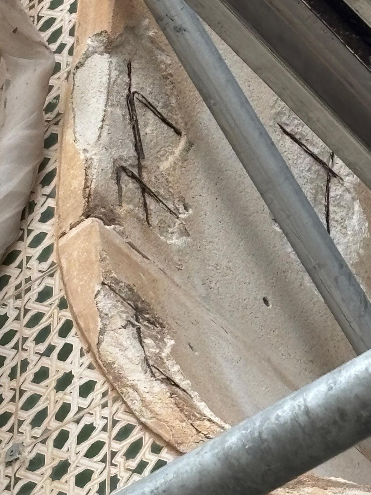 Canto de forjado con la armadura vista, junto a una celosía cerámica